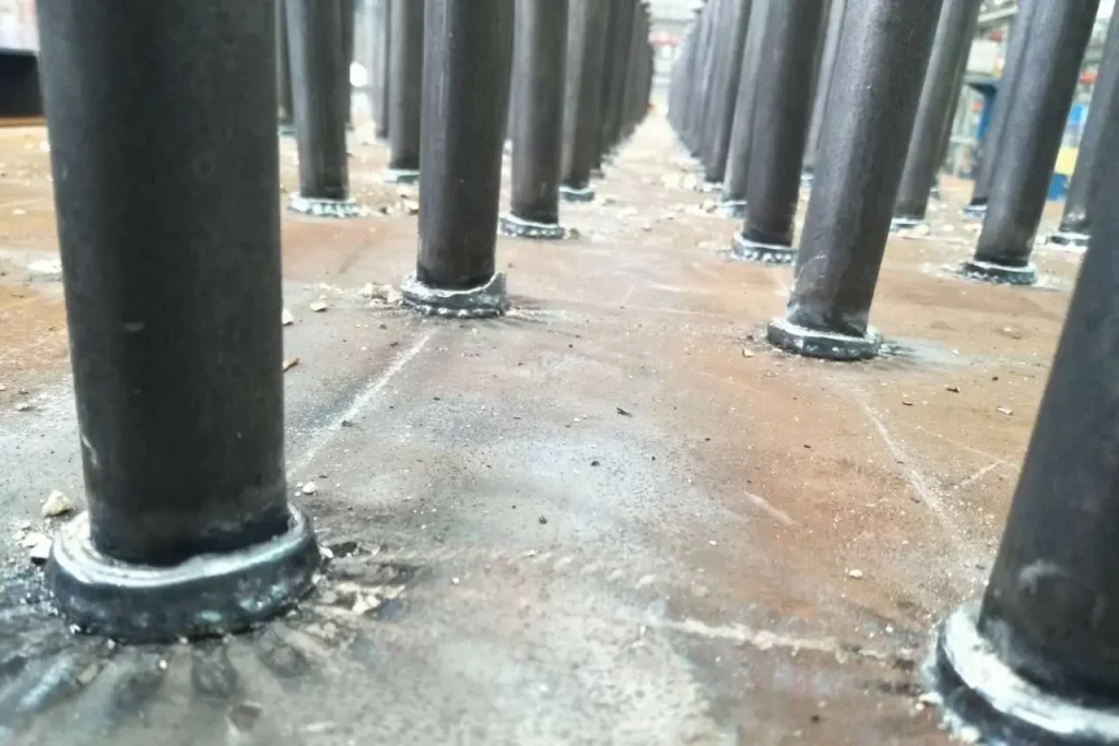 Close-up view of a completed shear stud weld, illustrating the clean, strong, and consistent fusion line of the structural shear connector to the steel base plate.