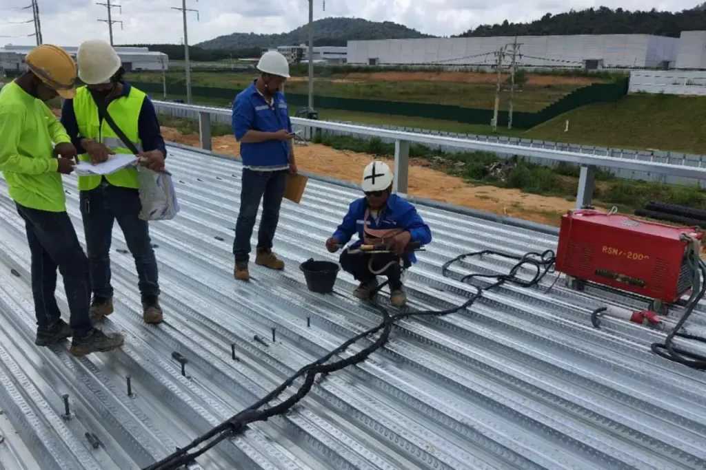 Action shot of a worker performing stud welding with sparks flying shear studs