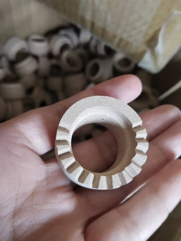 Hand holding a high-heat resistant ceramic ferrule with venting teeth.