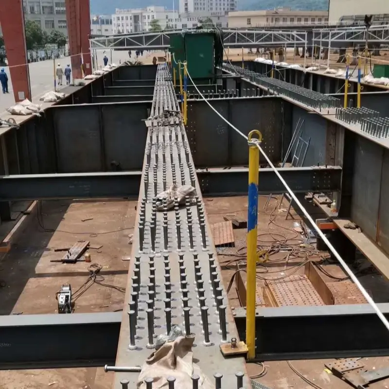 Close-up of headed shear studs welded on a steel I-beam for composite structure bridge construction.