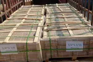Heavy-duty wooden crates and palletized cartons filled with weld studs prepared for international shipping.