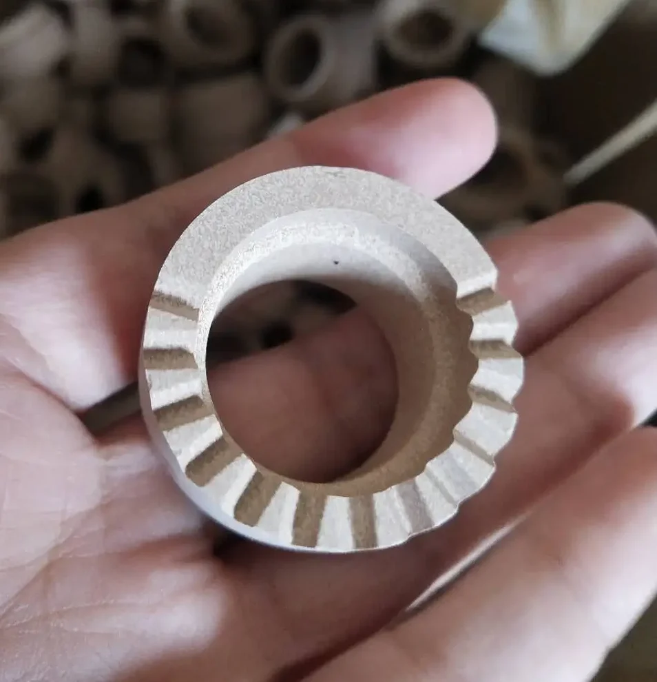 Hand holding a high-heat resistant ceramic ferrule with venting teeth.
